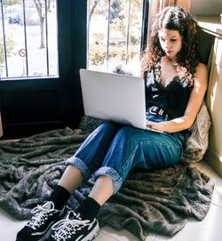 Young woman using mobile phone at home