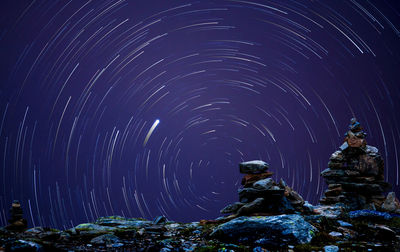 A startrail photography with polaris and rocks in the foreground