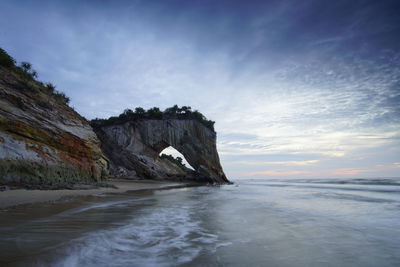 Rock formation on sea against sky