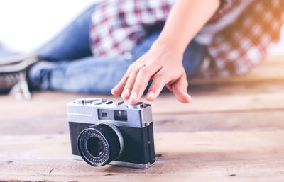 Low section of woman reaching camera on floor