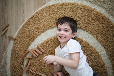 Boy caucasian brunette happy playing on the floor, casual lifestyle photo in real life interior