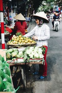 Portrait of woman with fruits for sale at market stall