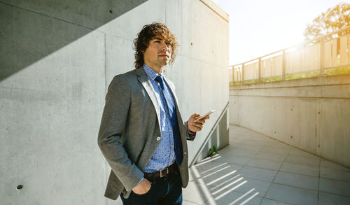 Man looking away while standing on mobile phone