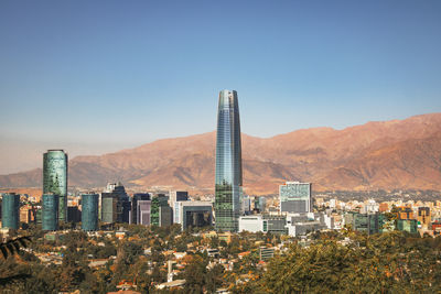 Buildings in city against clear blue sky