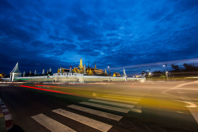 Light trails on road against sky at night
