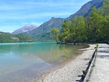 Scenic view of lake by mountains against sky