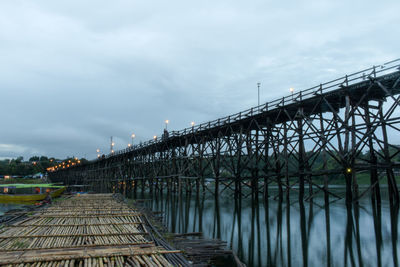 Bridge over river in city against sky