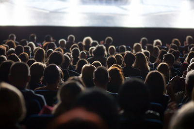 Rear view of people sitting in auditorium during seminar