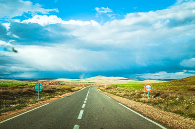 Road passing through landscape against sky