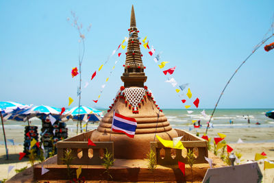Traditional windmill on beach against clear sky