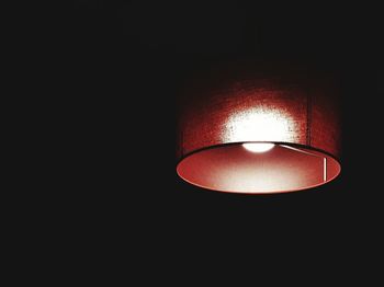 Low angle view of lit lamp in dark room