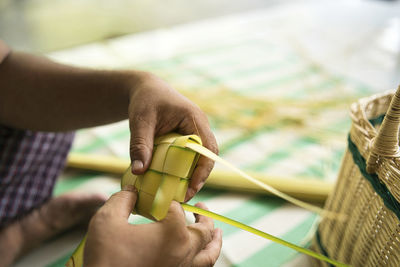 Weaving the coconut leaves making the ketupat, a traditional malay cuisine for the eid celebration.