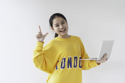 Young woman using mobile phone against white background