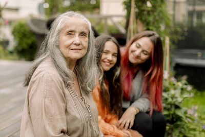 Portrait of senior woman sitting with daughter and granddaughter at patio