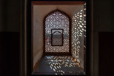 An patterned window casts elaborate shadows inside humayun's tomb, a landmark in delhi, india