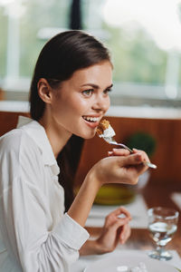 Portrait of smiling young woman drinking glass