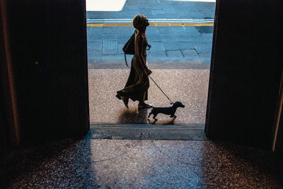 Woman with dog walking on floor