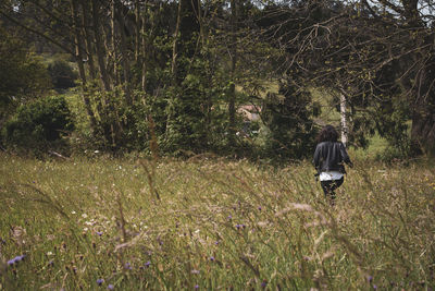 Rear view of people walking on field