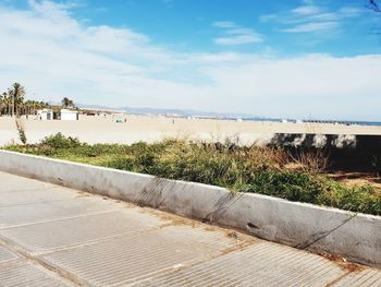 Footpath by sea against sky