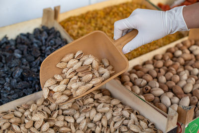 Buying nuts at grocery market woman in gloves chooses food safe shopping during coronavirus pandemic