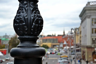 Close-up of statue against buildings in city