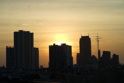 Modern buildings against sky during sunset