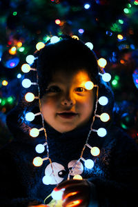 Portrait of girl in illuminated christmas lights