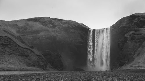 Scenic view of waterfall against sky