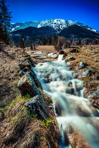 Scenic view of waterfall against sky