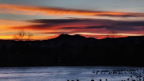 Scenic view of silhouette mountains against sky during sunset