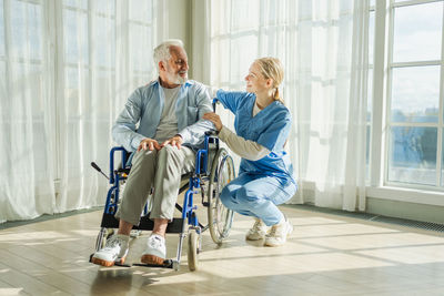 Full length of female friends exercising in gym