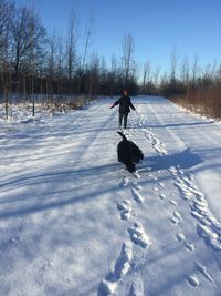 Woman with dog on snow covered field
