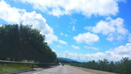 Empty road against cloudy sky