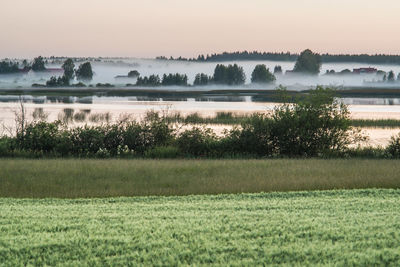 Scenic view of lake against sky at sunset