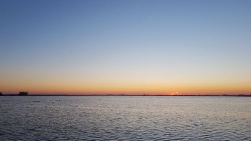 Scenic view of sea against clear sky during sunset