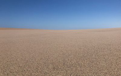 Scenic view of desert against clear blue sky