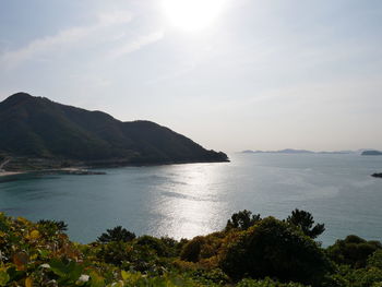 Scenic view of sea and mountains against sky