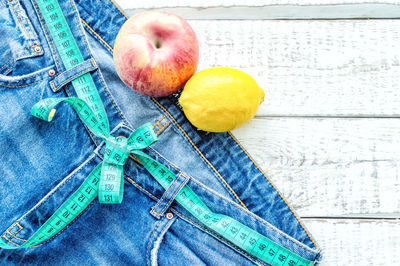 High angle view of jeans with fruit on table