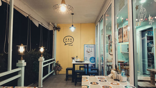 Empty chairs and tables in illuminated building