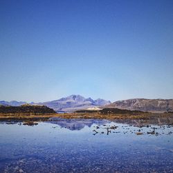 Scenic view of lake against clear blue sky