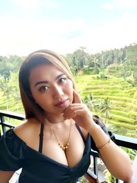 Portrait of beautiful woman standing against sky