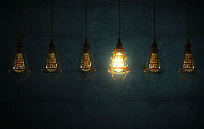 Low angle view of illuminated hanging light bulbs 