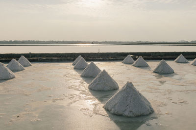 Lounge chairs on beach against sky