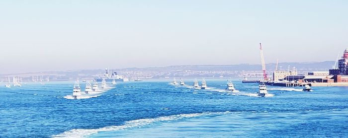 Sailboats in sea against clear sky