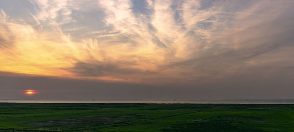 Scenic view of field against sky during sunset