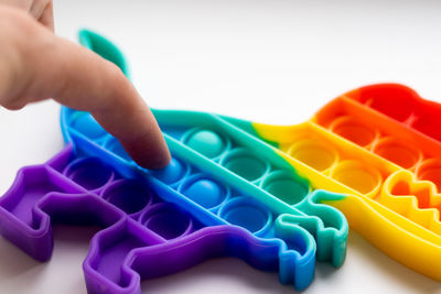 Close-up of hand holding toy against white background