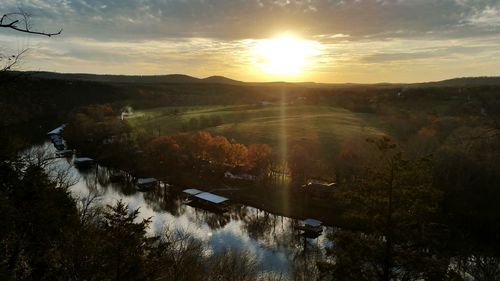 Scenic view of agricultural landscape against sky during sunset