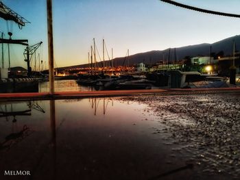 Boats moored at harbor during sunset