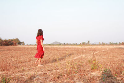 Woman on field against clear sky