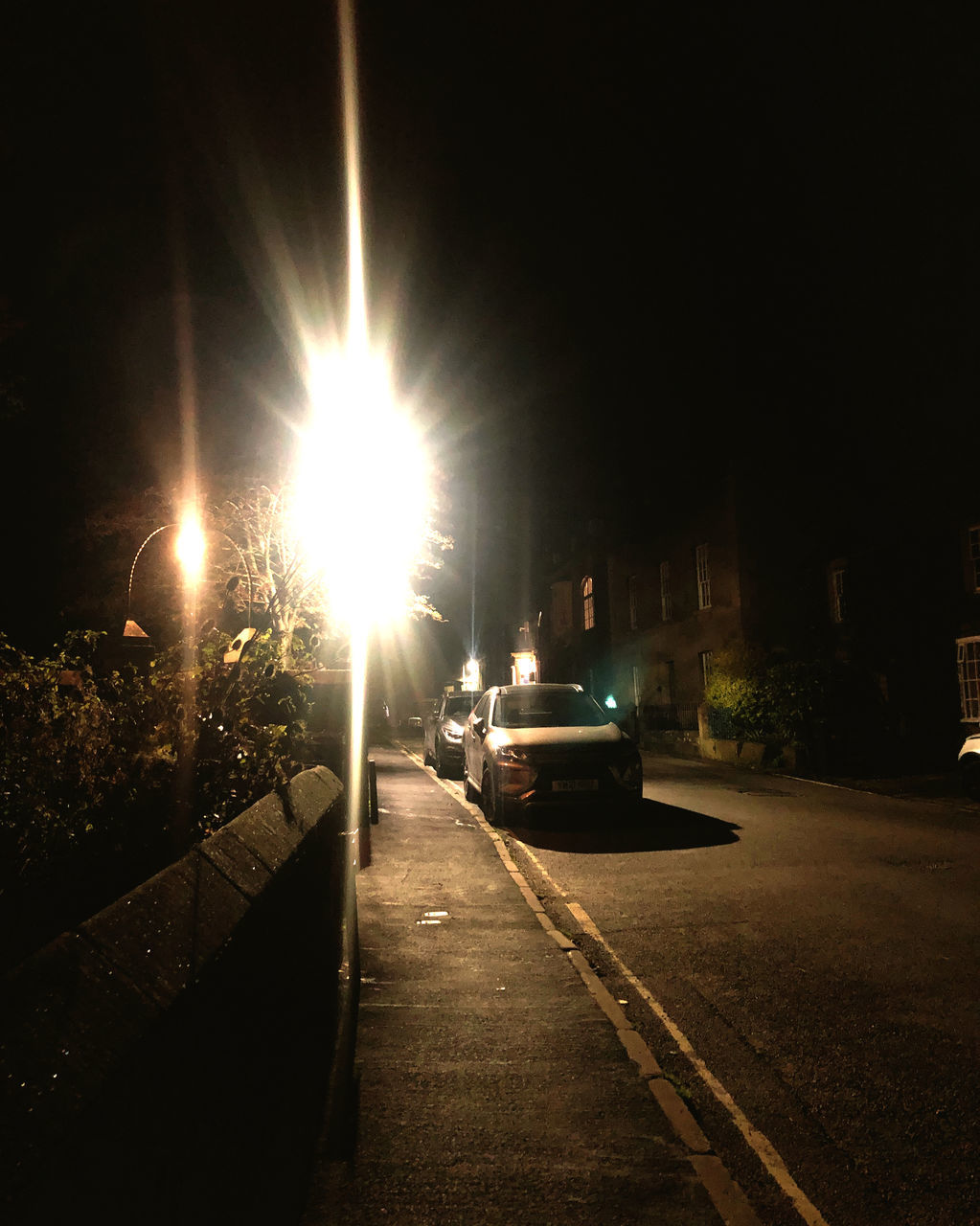 CITY STREET AMIDST BUILDINGS AT NIGHT